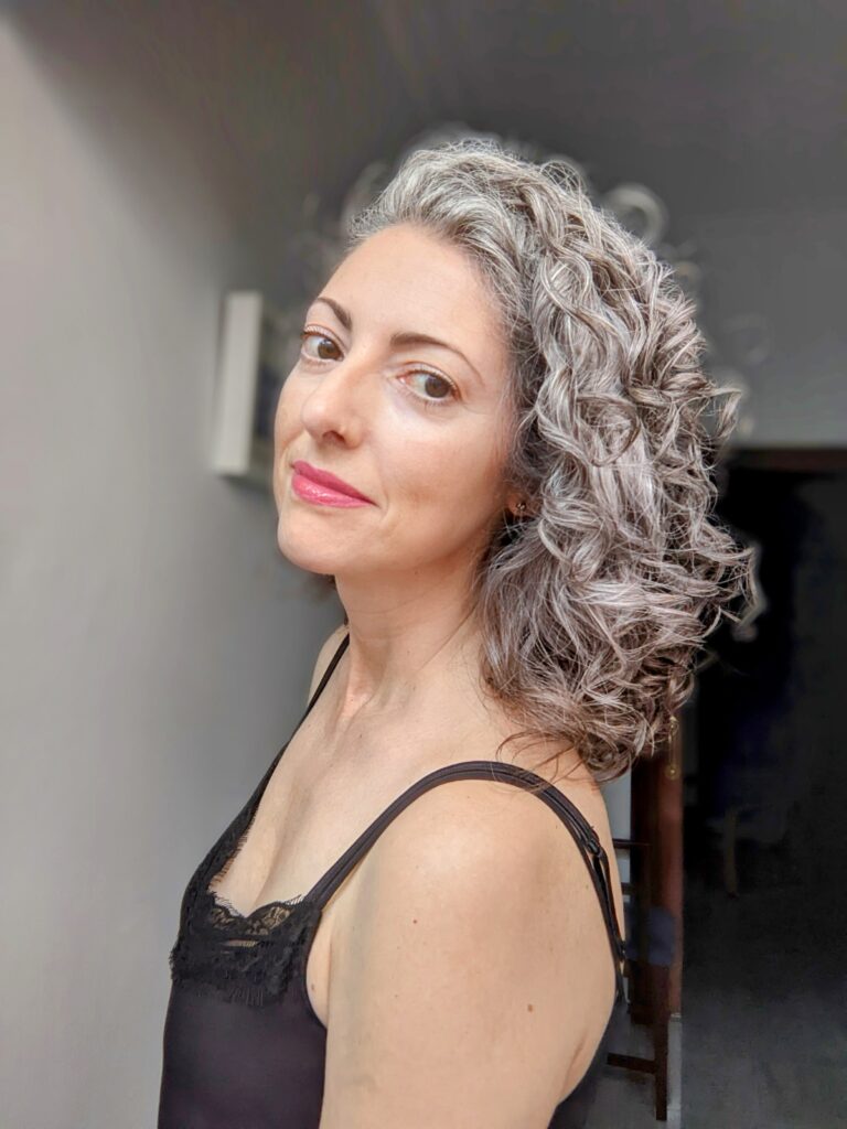 Mujer con cabello gris rizado por los hombros